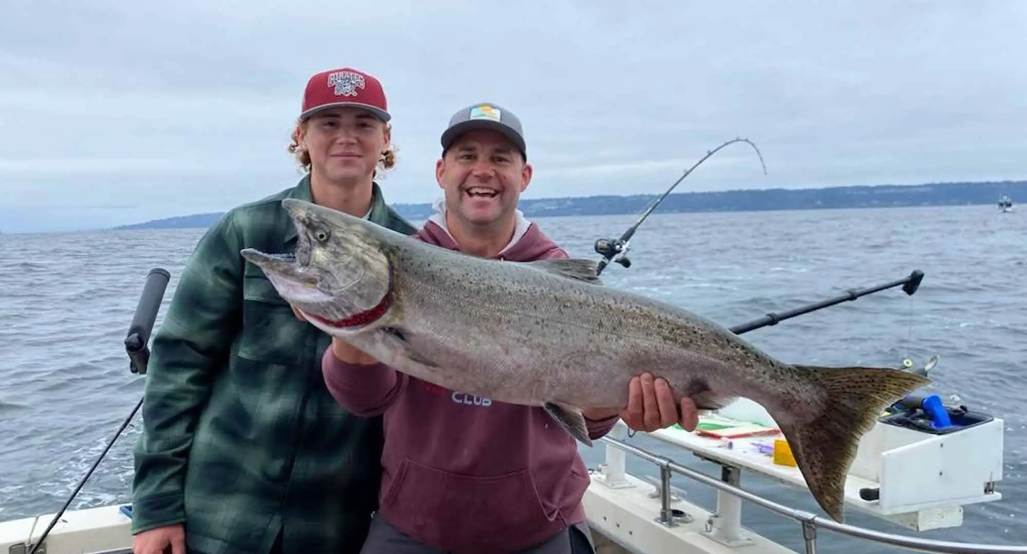 Seattle fishing charters — anglers landing Chinook on Puget Sound